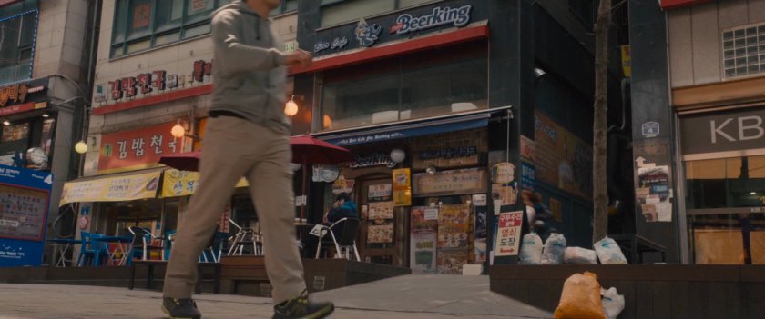 The Black Widow on a motorcycle exits a narrow alley.