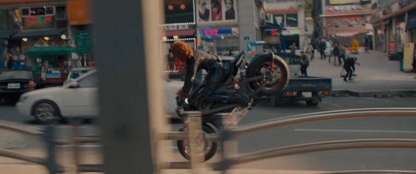 The Black Widow on a motorcycle does a front wheelie.