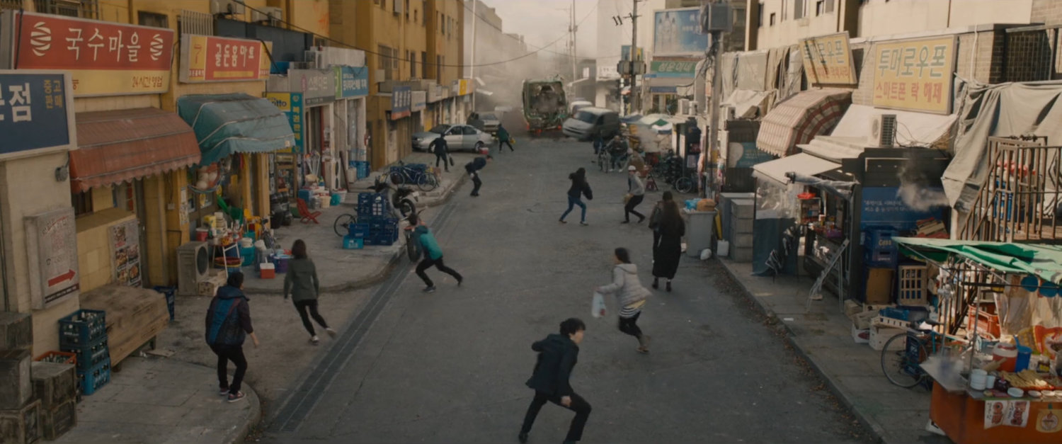 Pedestrians scatter from street as speeding train heads towards them.