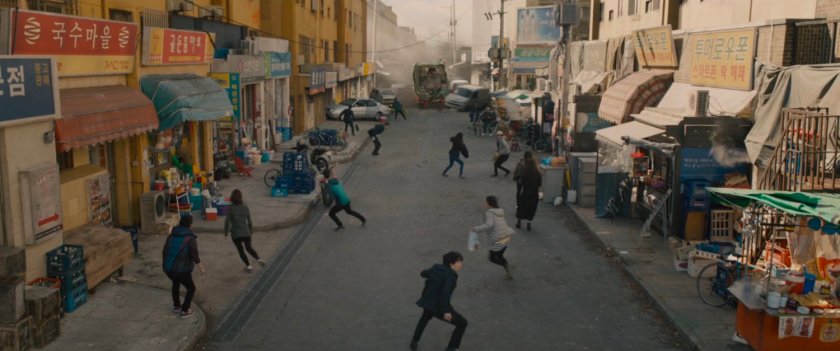 Pedestrians scatter from street as speeding train heads towards them.