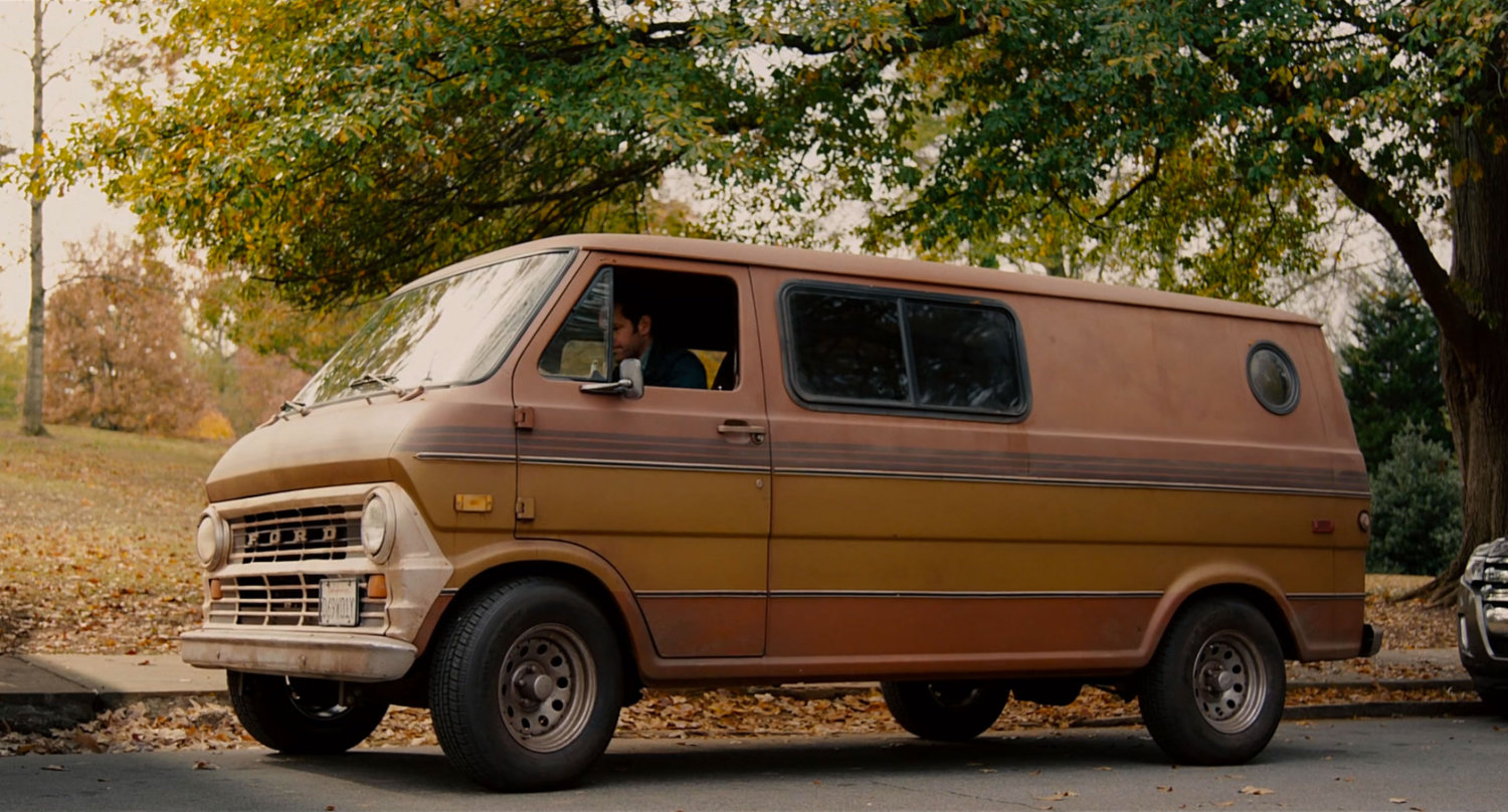 Brown van parked in front of park.