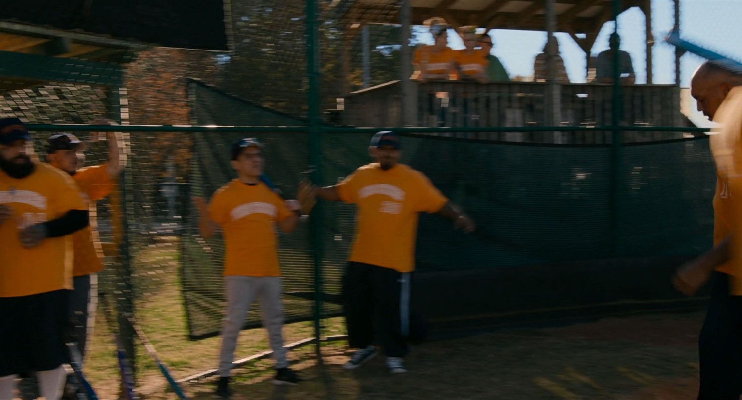 Men with yellow shirts at a baseball park.