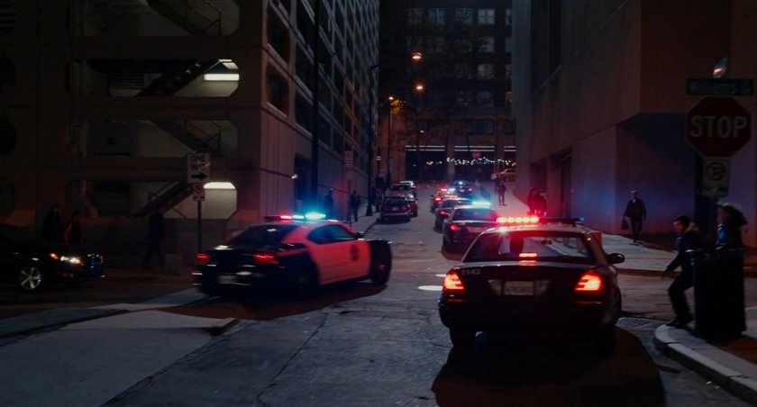 Police cars race up San Francisco street.