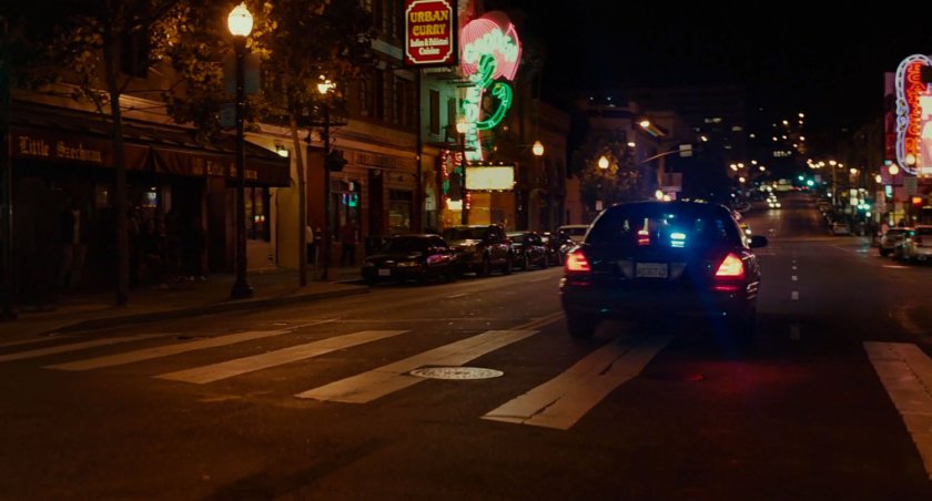 A police car on a nighttime drive down a San Francisco street.