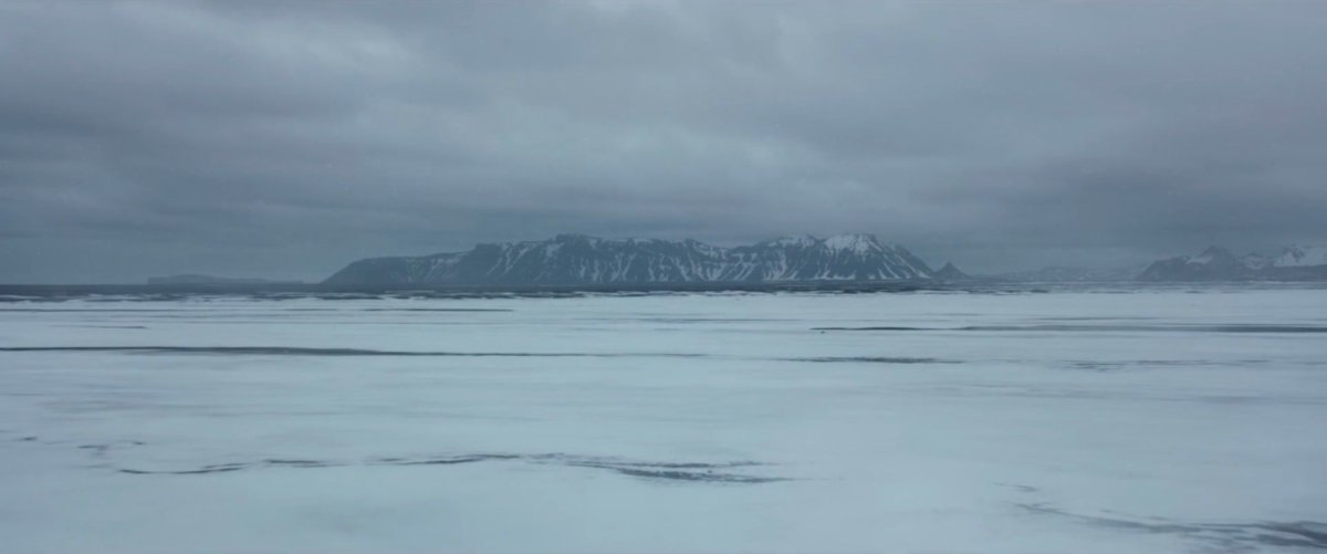 A icy plain with mountains in the distance.