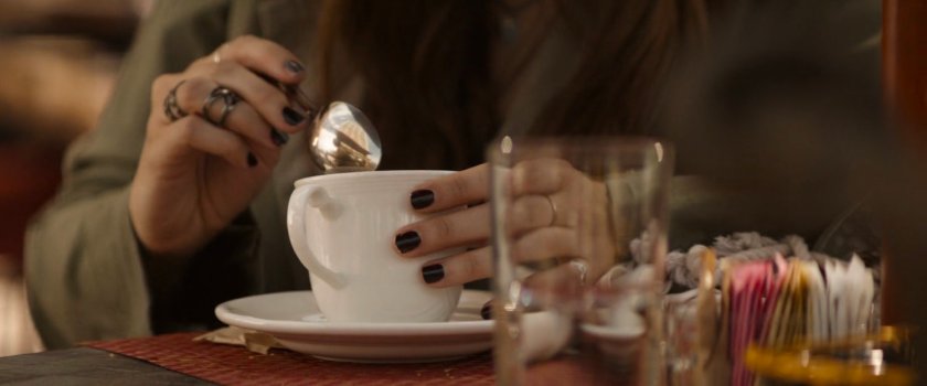 Close-up of Wanda stirring her coffee with a spoon.
