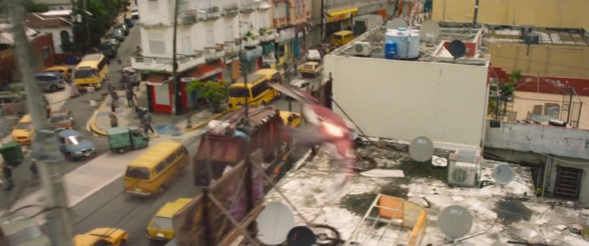 Redwing flying over Lagos street following garbage truck.