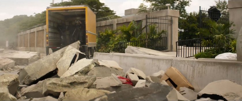 Yellow box truck inside IFID courtyard, strewn with rubble.