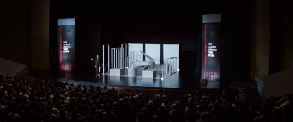 Tony Stark on stage at an MIT auditorium.