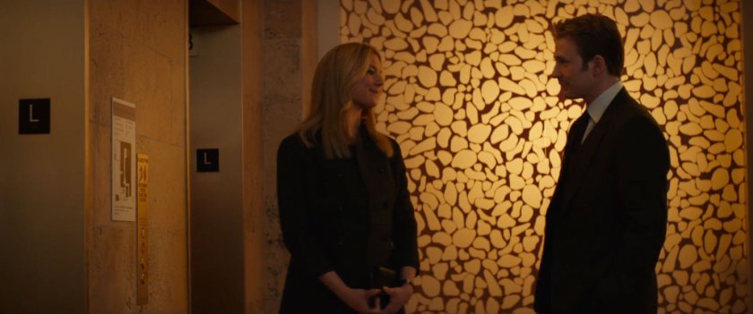 Sharon Carter and Steve Rogers talking by hotel lobby elevator.