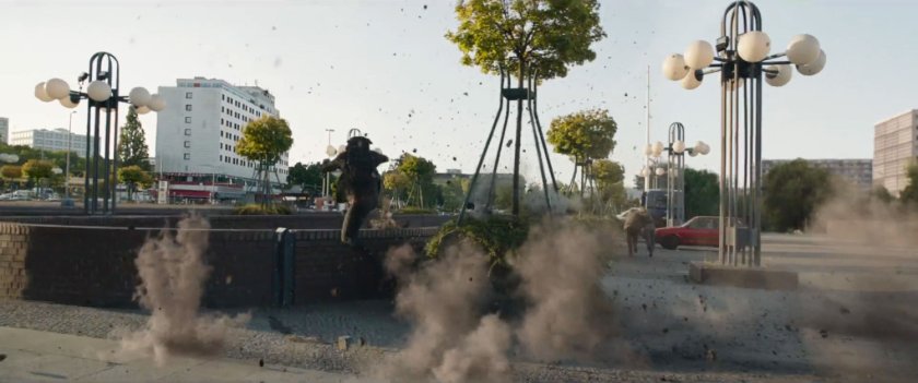 Gunfire raises smoke in a Bucharest plaza as Bucky leaps into brick well.