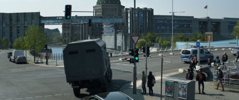 An armored truck turns right on a Berlin street.