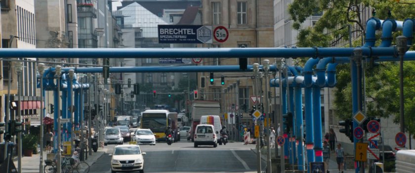 View down Berlin road with blue pipes and traffic.