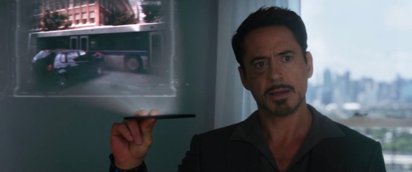 Tony Stark showing a holographic video of Spider-Man stopping car from hitting bus.