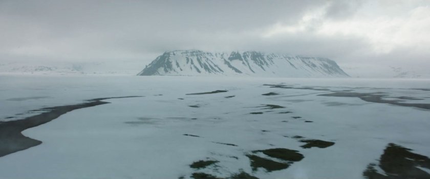 A snowy Siberian plain with mountains in the distance.