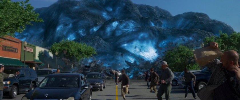 A giant alien spore chases people down a street.