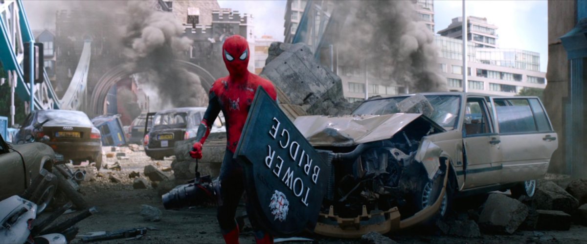 Spider-Man holds a Tower Bridge sign as a shield on a bridge full of smoking debris.