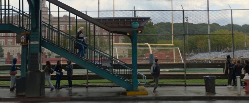 Subway stairs exit onto sidewalk with Midtown High in background.