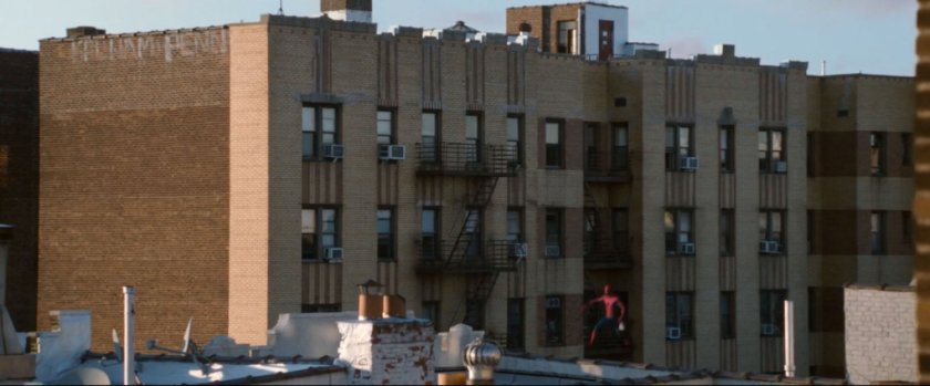 Wide shot of Spider-Man landing on a Queens rooftop.
