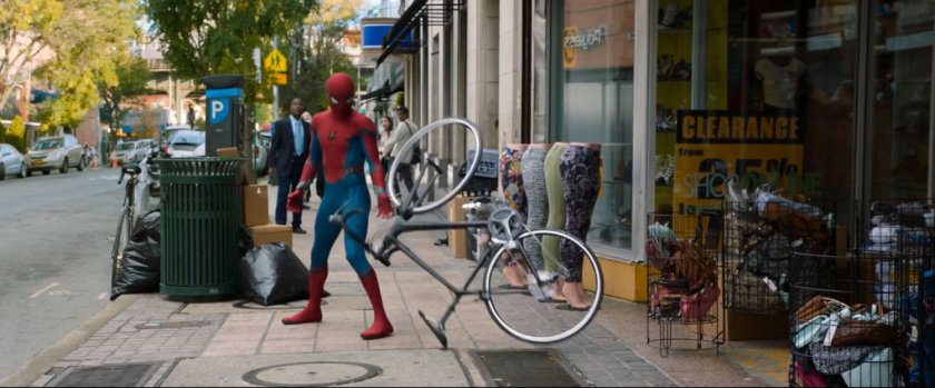 Spider-Man standing next to a bike that is riderless.