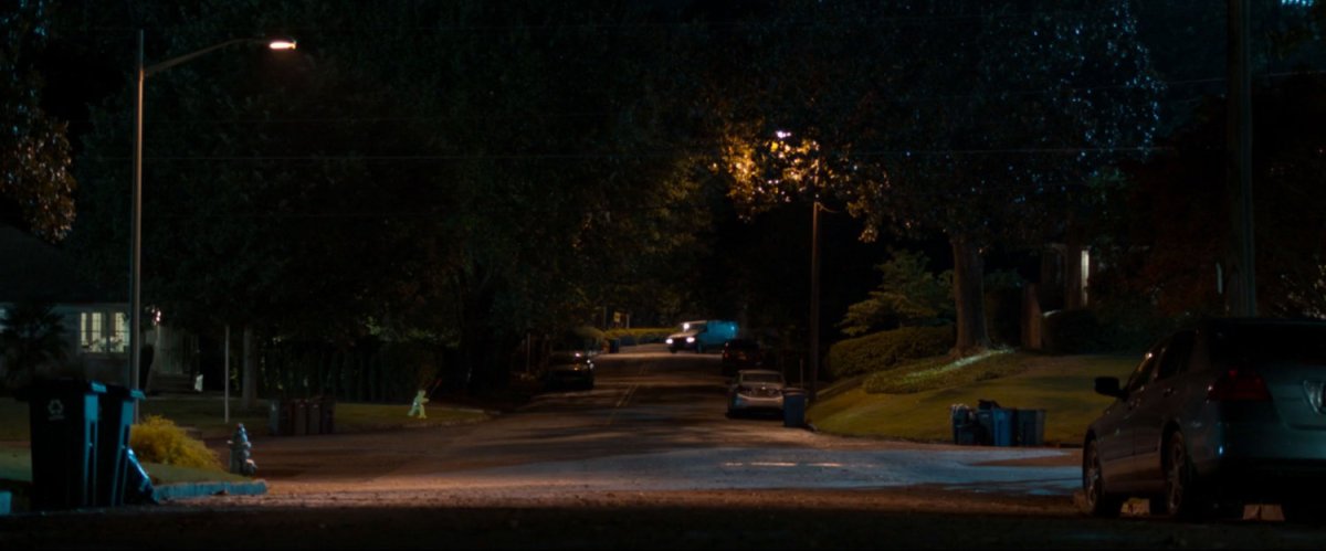 Van turns into residential neighborhood at night.