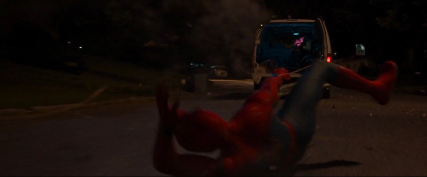 Spider-Man dragged by webbing behind van.