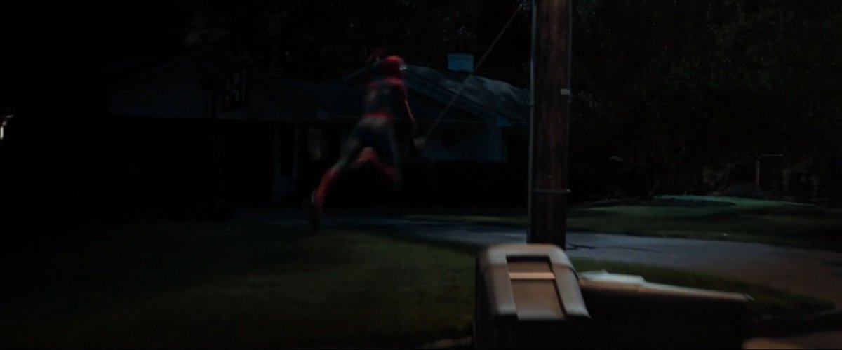 Spider-Man swings past a residential neighborhood.