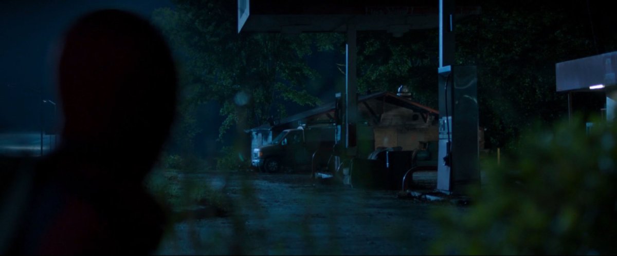 Peter spies on a van at a derelict gas station.