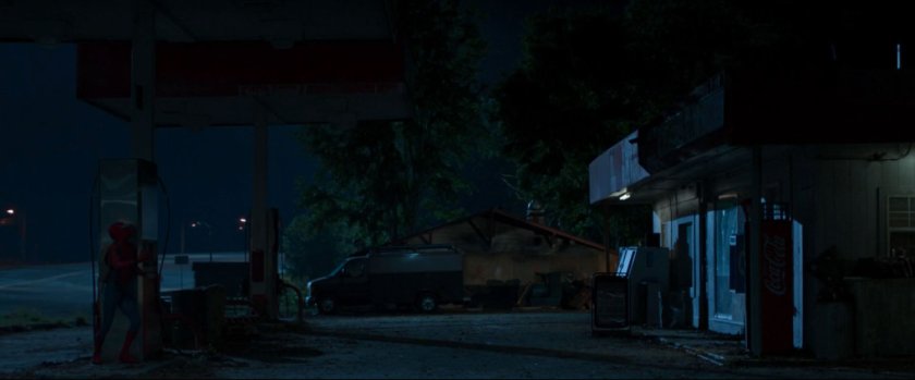 Peter spies on a van at a derelict gas station.