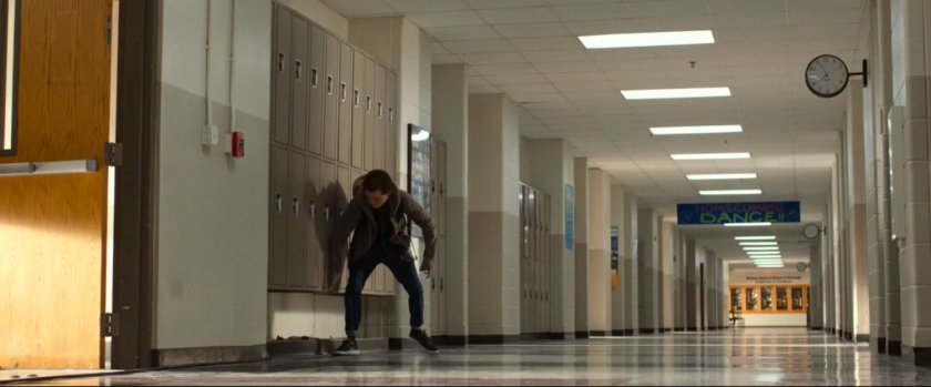 Peter Parker lifting up lockers in Midtown High hallway.