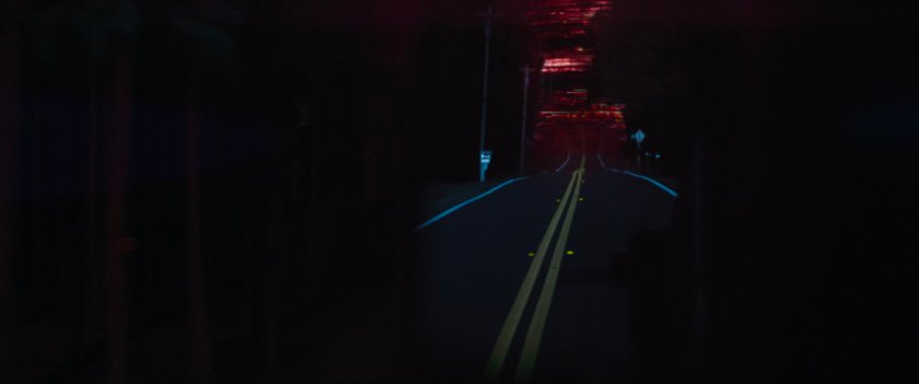 A red sky above a road at night.