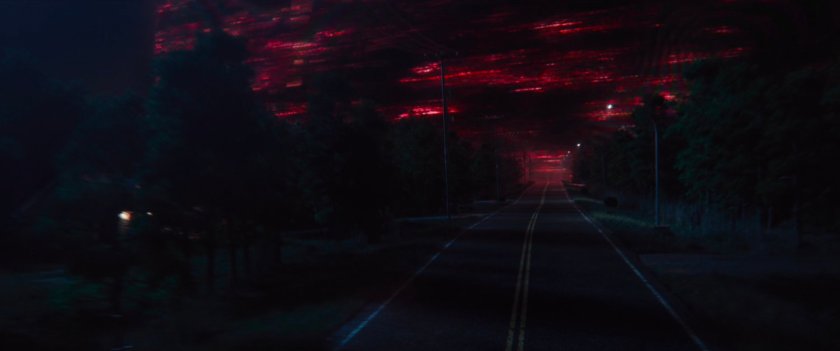 A red sky above a road at night.