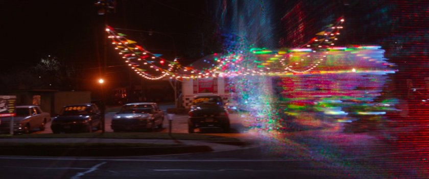 A red energy curtain sweeping across used car lot.