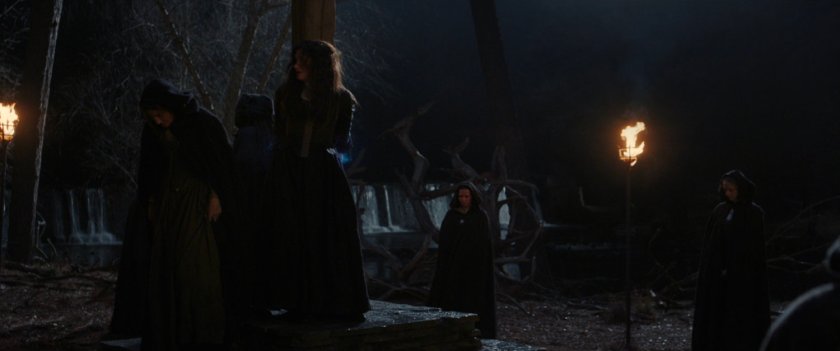 Witches tie up Agnes in a small wooded clearing.