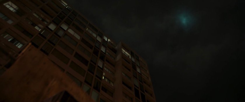 Looking up at the side of an apartment building at night.