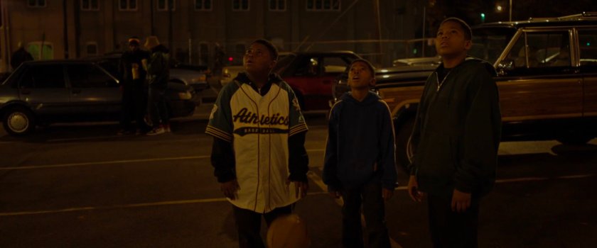 Three young boys looking up into the night sky.