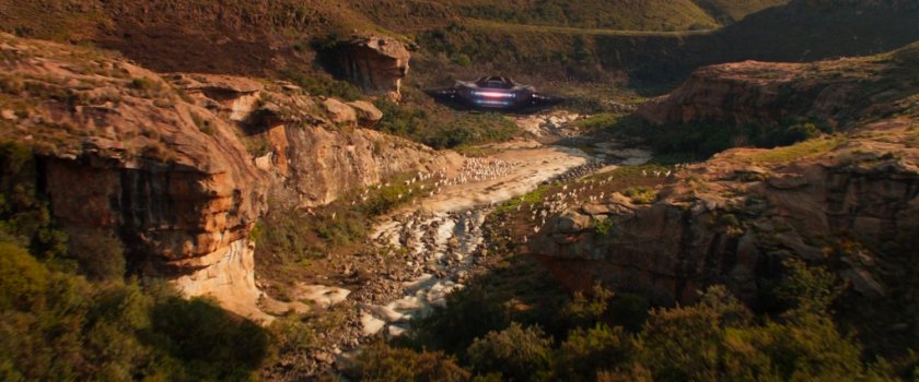Talon fighter flying through a Wakandan valley.