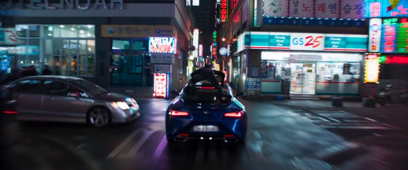 Black Panther atop a car driving through a narrow Busan street.