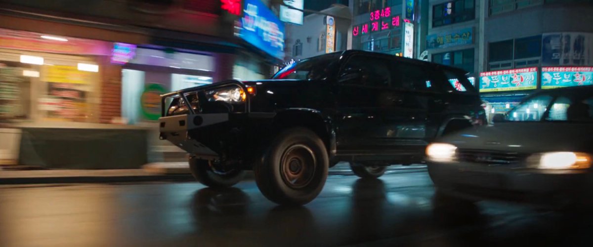 Close-up of SUV racing along Busan street.