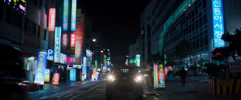 SUV racing along Busan street outside seafood market.