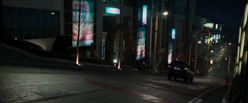 SUV racing down a hilly Busan street.