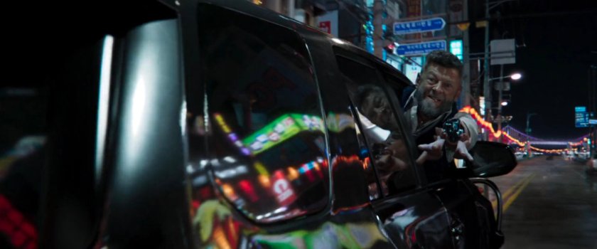 Close-up of Klaue leaning out of SUB window with arm outstretched.