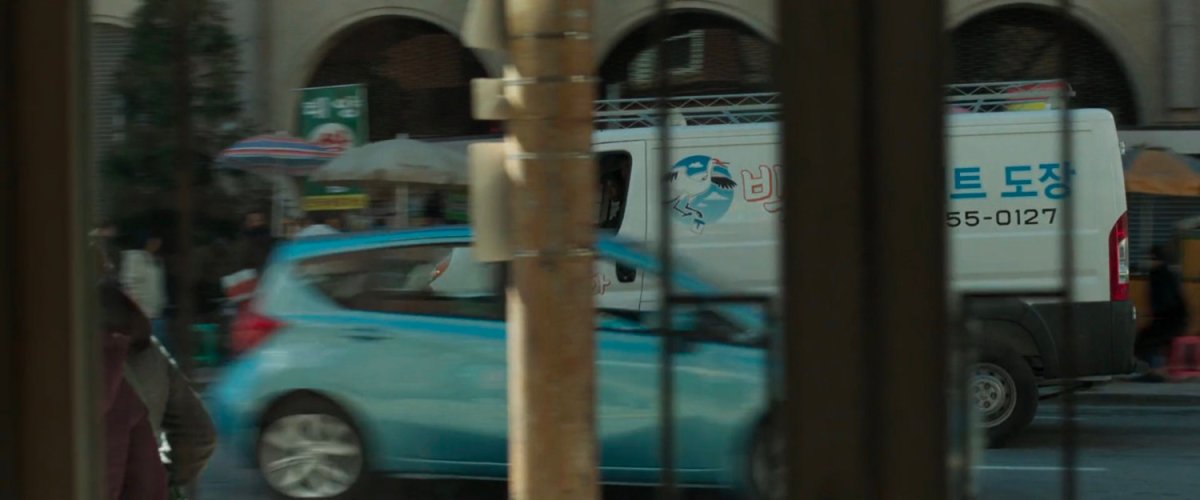 A white van cruises past a police station in Busan.