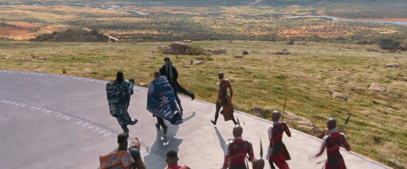 Wakandan warriors run towards a large field.
