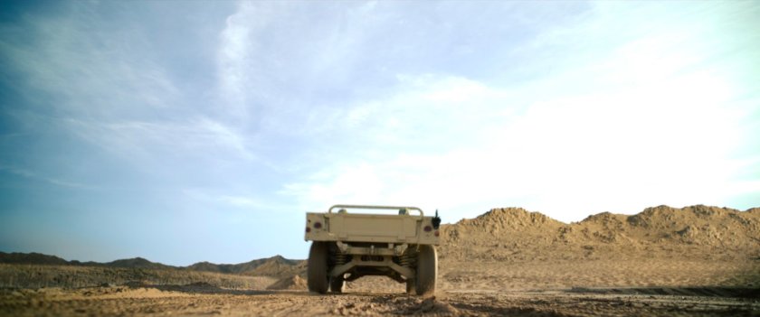Low angle of humvee on desert road.