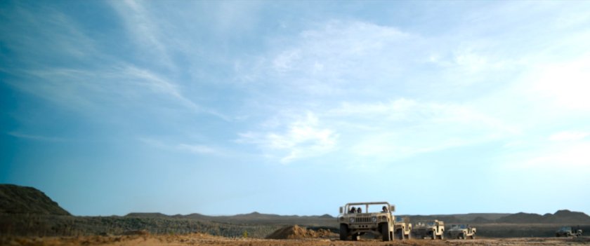 Low angle of humvees on desert road.