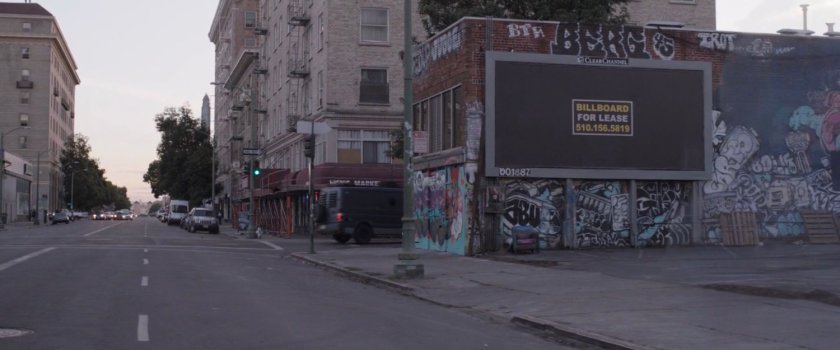 Billboard in empty lot next to intersection.