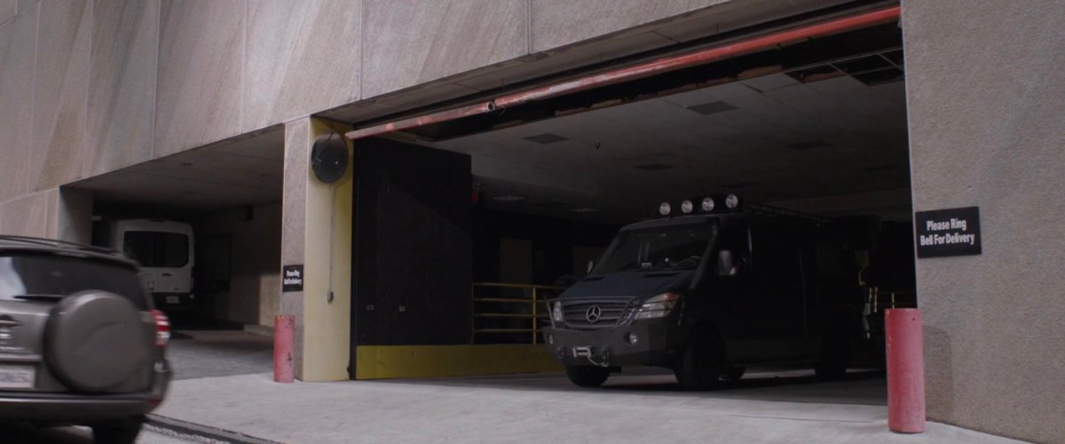 Van parked inside loading dock at building.