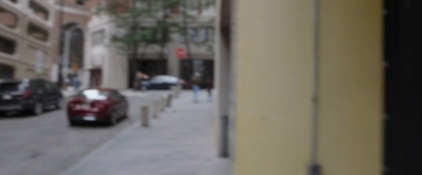 Out of focus image of street and sidewalk.