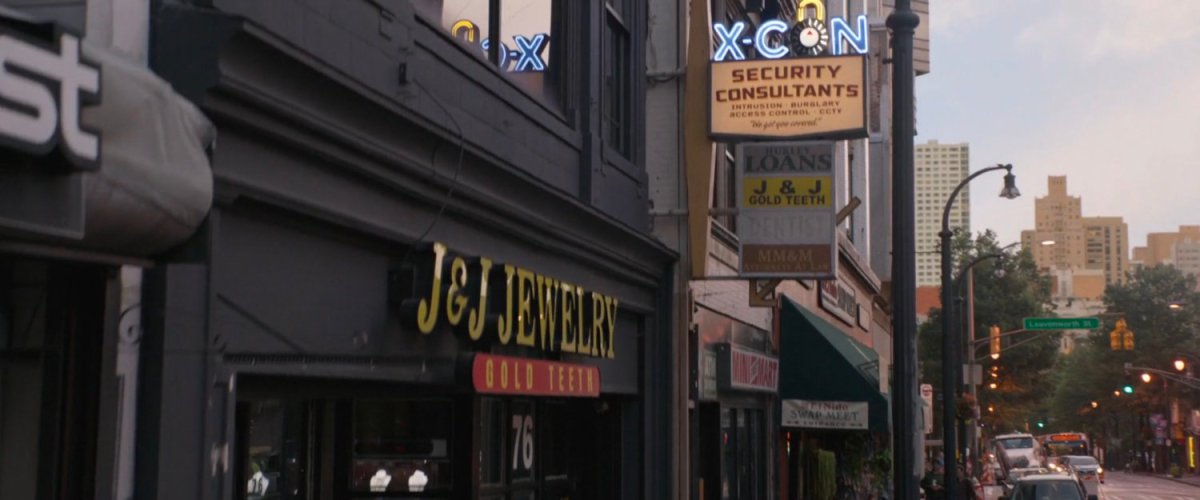 Store fronts with signage including X-Con Security Consultants.